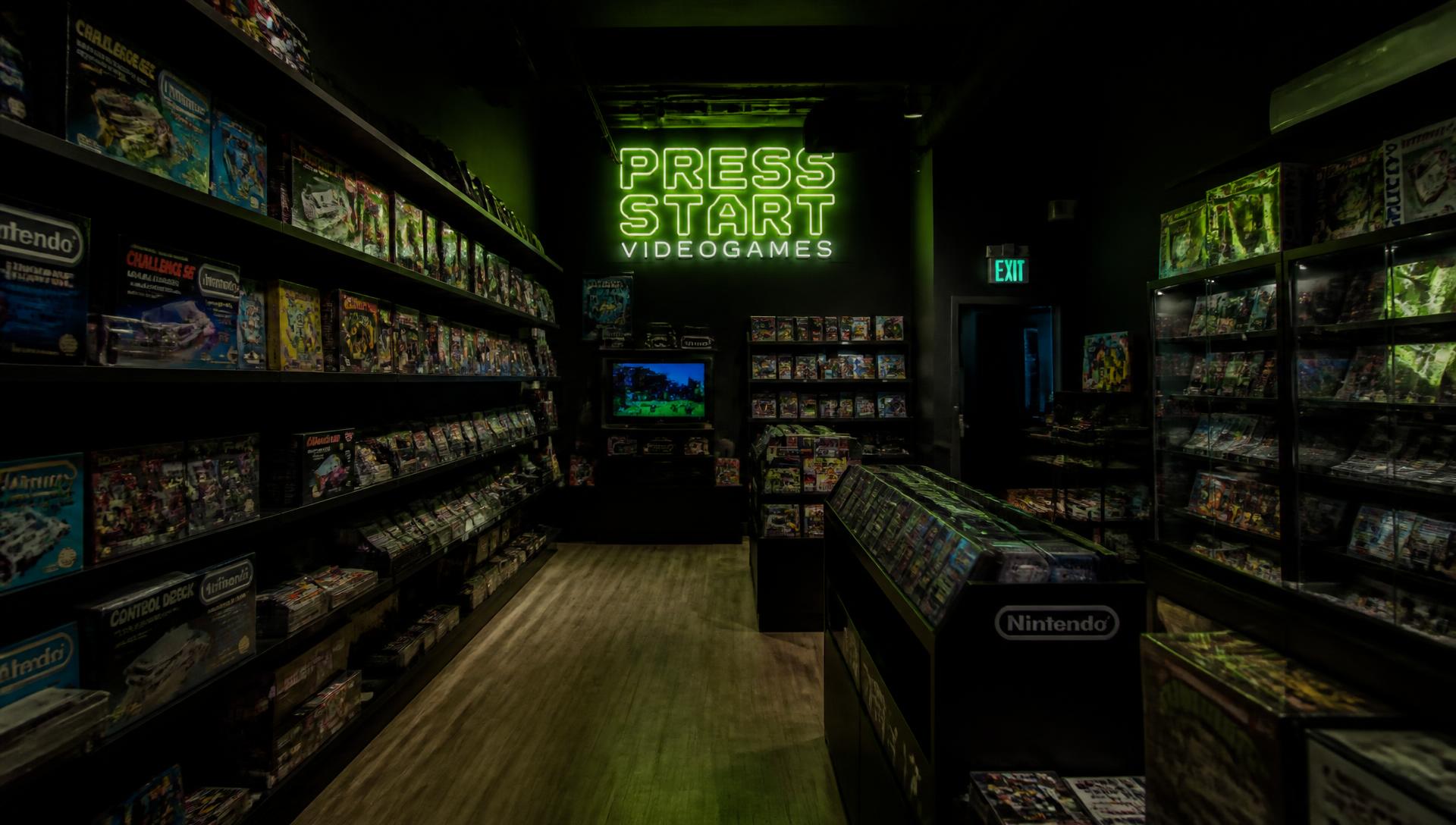 Interior of Limit Break Retro Games & Collectables, shelves of boxed retro consoles under a green neon sign